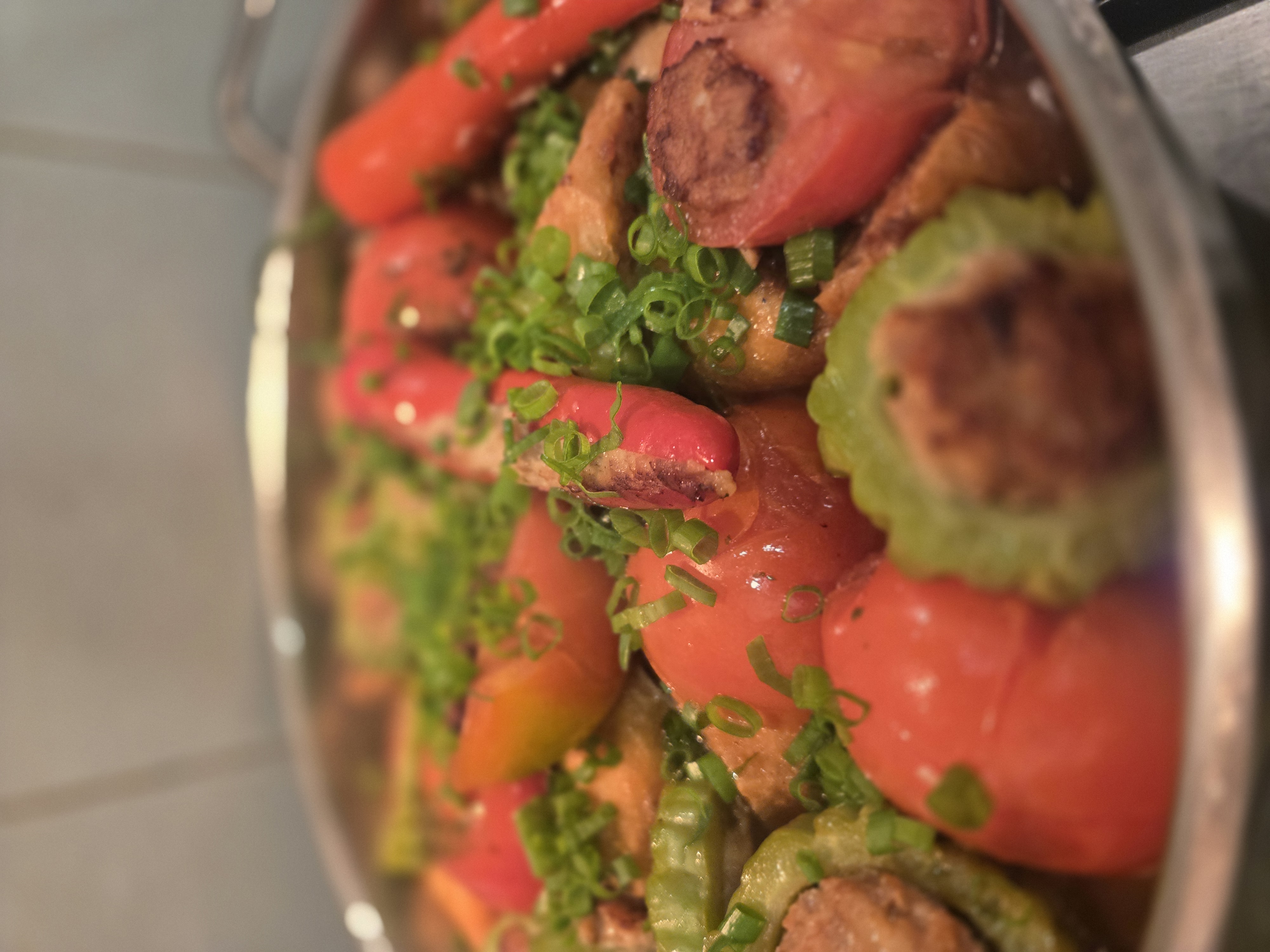 Finished yong tau foo: golden-seared stuffed vegetables in a clear braising stock with spring onion